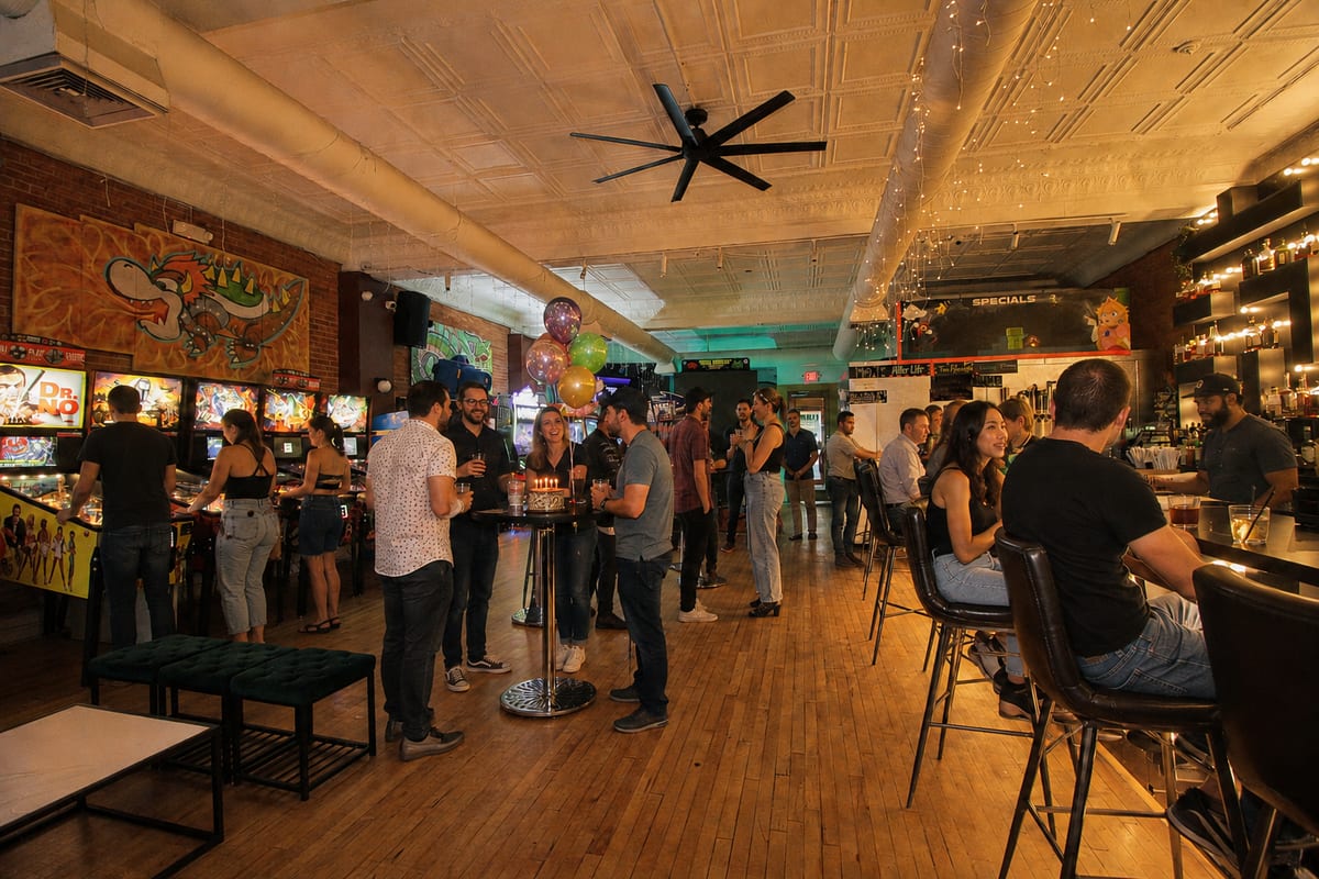 Guests mingling with drinks on the arcade floor at 1UP Arcade Bar